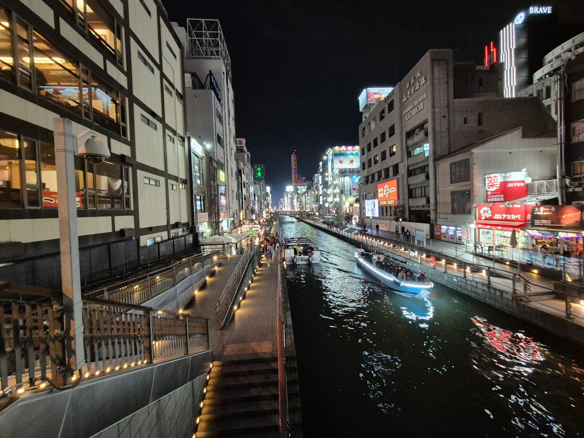 El canal de Dotonbori en Osaka iluminado de noche, con los letreros de neón reflejándose en el agua